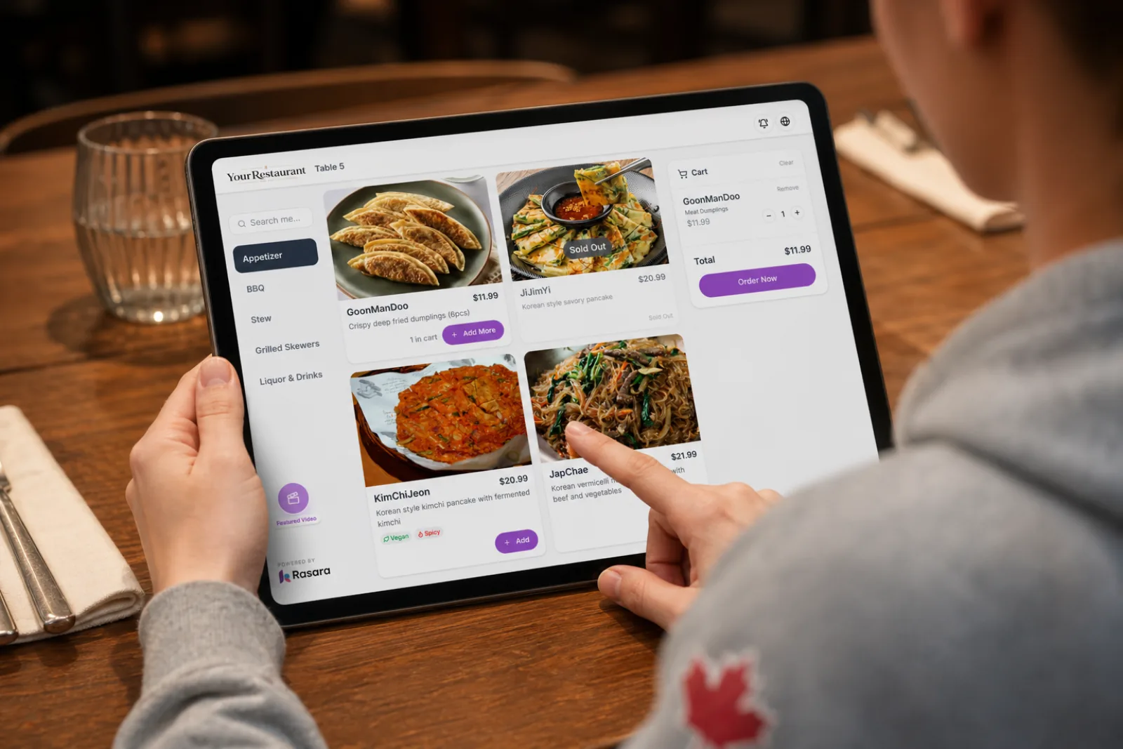A guest choosing dishes on a tablet menu at a restaurant table